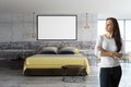 Woman in loft room with blank poster Royalty Free Stock Photo