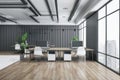 Front view on wooden tables with modern computers, white chairs on wooden floor, grey metallic decorative wall and city view from Royalty Free Stock Photo