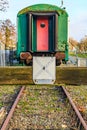 Front view of wooden terminal bumper stop with an old train carriage in background Royalty Free Stock Photo