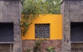 Front view of a yellow wall made of stones and bricks with tree branches covering it. Buddhism concetp Royalty Free Stock Photo