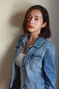 Front view young adult asian sexy woman, red lip and short hair in blue jean with beauty face standing and looking at camera Royalty Free Stock Photo