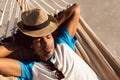 Man with hat sleeping in a hammock on the beach Royalty Free Stock Photo