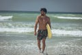 Young male surfer with a surfboard walking at beach Royalty Free Stock Photo