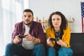 Front view of young couple holding joysticks