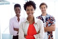 Business people with arms crossed looking at camera in a modern office