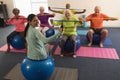 Young female trainer and senior people exercising with resistance band Royalty Free Stock Photo