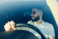 Front view, young handsome man looking straight while driving a car Royalty Free Stock Photo