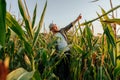 Front view young joyful farmer male stand in cornfield raised hands up show sky, Royalty Free Stock Photo