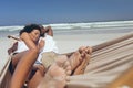 Young couple relaxing on hammock at beach on sunny day Royalty Free Stock Photo