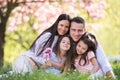 Young parents with small daugthers sitting outside in spring nature. Royalty Free Stock Photo