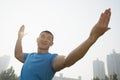 Front view of young, smiling, muscular man stretching, hands outstretched in Beijing, China