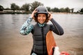 Front view of young smiling woman wearing life jacket putting helmet on her head Royalty Free Stock Photo