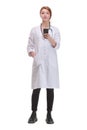 Front view of young woman doctor holding her smartphone Royalty Free Stock Photo