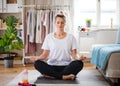 Young woman doing yoga exercise indoors at home, meditating. Royalty Free Stock Photo