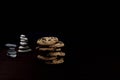 Front view of Zen Pile of chocolate Chips with a stones pile in the back and dark background