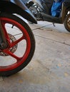 the front wheel of an automatic motorbike with red wheels Royalty Free Stock Photo