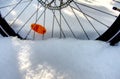 Front wheel of bicycle sunk deep in soft snow with the valve and an orange reflector Royalty Free Stock Photo
