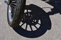 Shadow of a motorcycle wheel and tie