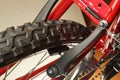 Detail of the bike. The front wheel of the red bicycle with visible V-brake