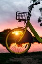 Front wheel of a yellow bike on the lake. Sunset Royalty Free Stock Photo