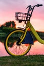 Front wheel of a yellow bike on the lake. Sunset Royalty Free Stock Photo