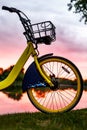 Front wheel of a yellow bike on the lake. Sunset Royalty Free Stock Photo