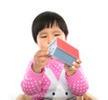 In front of the white background, the little girl is playing with a small house model Royalty Free Stock Photo