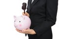 In front of the white background, the man in formal clothes is ready to break the piggy bank with a wooden hammer Royalty Free Stock Photo