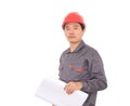 In front of white background a worker holding engineering drawings wearing a red hard hat looking at the camera Royalty Free Stock Photo