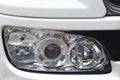 A front width headlight assembly unit on a white painted luxury car