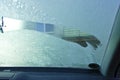 The front windshield of a car is scraped from the ice in winter, inside view Royalty Free Stock Photo
