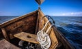 Front of wooden fishing boat with anchor on board , white rope. Royalty Free Stock Photo