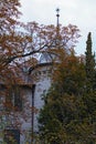 Front yard garden is hiding ancient house with the tower. Beautiful autumn landscape. Petofi Sandor street in Balatonfoldvar