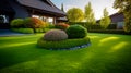 Front yard, landscape design with multicolored shrubs intersecting with bright green lawns behind the house is a modern, garden Royalty Free Stock Photo