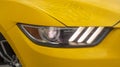 Front of a yellow car with the autobot logo closeup
