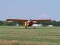 Front of yellow Yakovlev Yak-12M SP-AWG airplane lands on grassy airfield in european Bielsko-Biala city in Poland