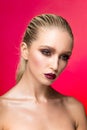 Frontal beauty portrait of young woman with perfect makeup over red background