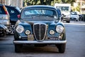 The frontal part of the legendary Lancia Aurelia B20 GT vintage car in Iraly with an old black number plate