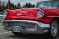 Frontal photo of a classic luxury red car. Color detail on the headlight of a vintage car. Front of an old American car Royalty Free Stock Photo