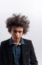 Close-up frowning young man with crazy awesome hair, in jacket, standing and looking at camera, over white background. Royalty Free Stock Photo