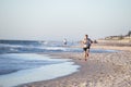 Athletic fit and strong runner man training on Summer sunset beach in sea shore running and fitness workout in sport and healthy l Royalty Free Stock Photo