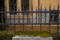 Frontal view of Black metal steel fence in a city. Rustical vintage style fence with spiked tops and rivets visible