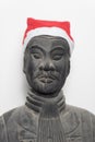 Frontal view of Chinese terracotta warrior statue wearing a santa hat