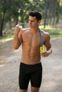 Handsome man in sportwear doing exercise outside in park. Healthy lifestyle concept. Vertical view.