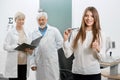 Frontview of satisfied patient smiling in front of old oculist and assistant.