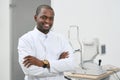 Frontview of smiling man standing near medical equipment .