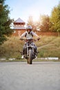 Frontview of young strong biker riding on sport motorcycle.