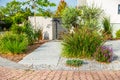 The frontyard of a modern house, garden details with colorful plants and dry grass beds with path Royalty Free Stock Photo