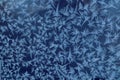 Frost draws: a pattern of different elements on the window glass on a frosty morning, close-up, blue color