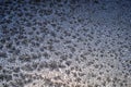 Frost patterns on glass in winter. Looks like falling leaves or fluff. Dark blue abstract background or wallpaper. Weather Royalty Free Stock Photo